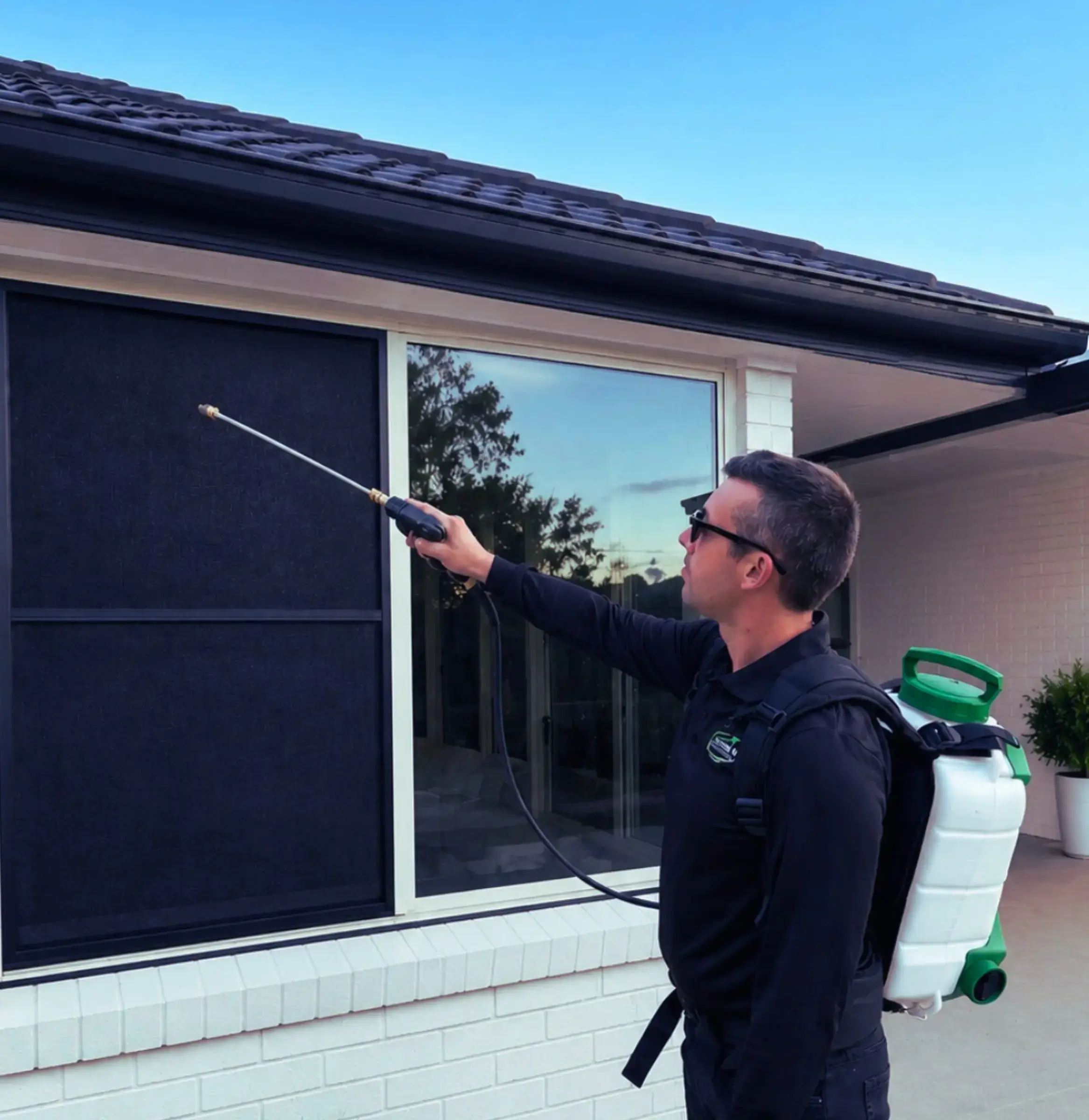 Urban Pest & Termite Solutions technician treating a home exterior